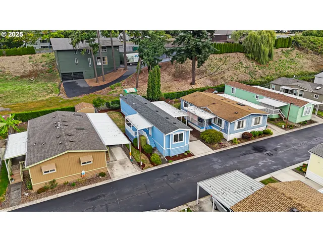 an aerial view of residential houses with outdoor space and parking