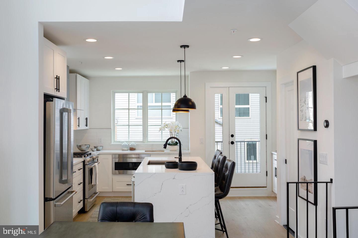 3401 Hamilton Street, Unit 4 Philadelphia, PA 19104 - Photo 23 of 33 a kitchen with stainless steel appliances a refrigerator a sink a stove a dining table and chairs