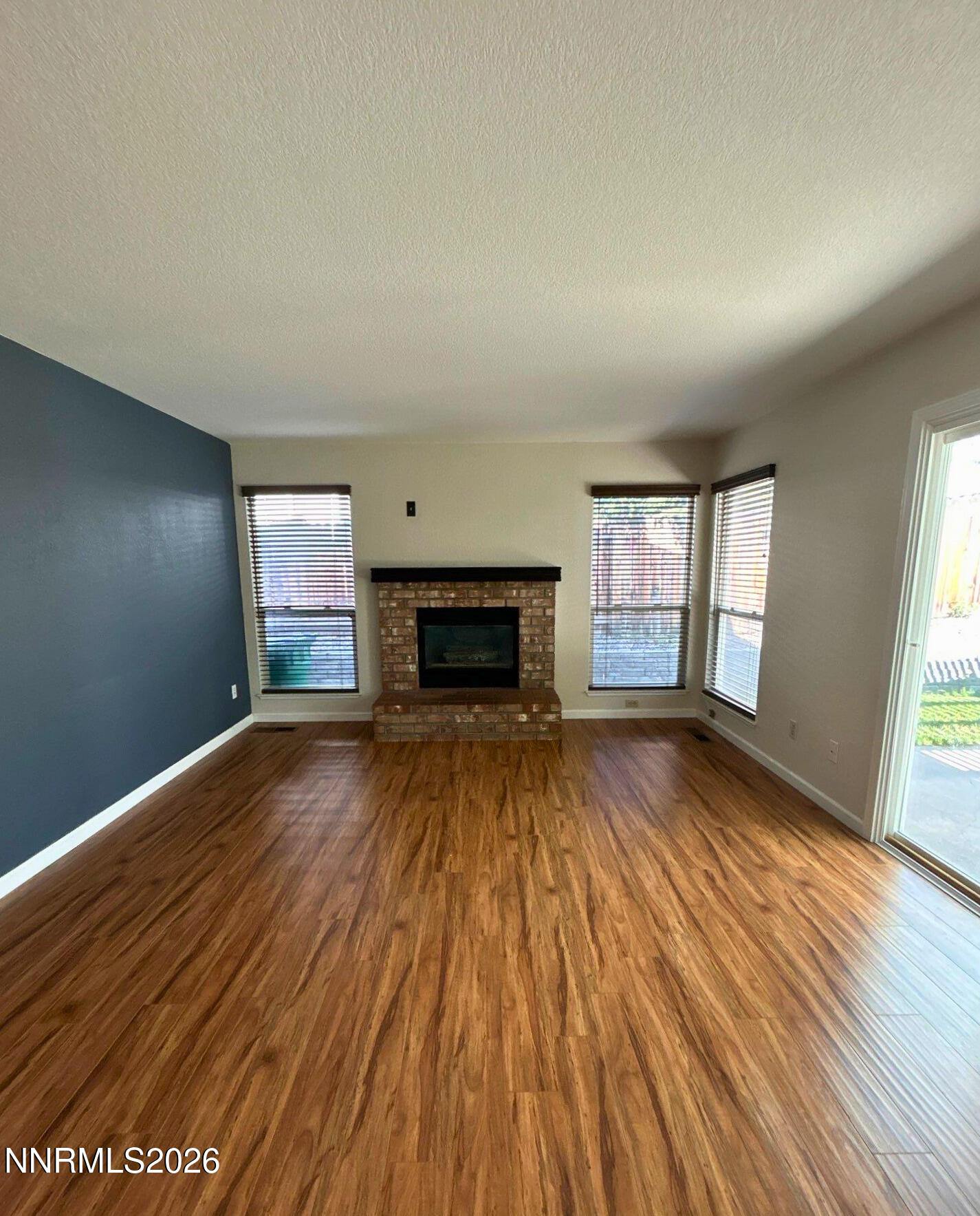 4437 Highplains Drive Reno, NV 89523 - Photo 9 of 19 wooden floor fireplace and windows in an empty room