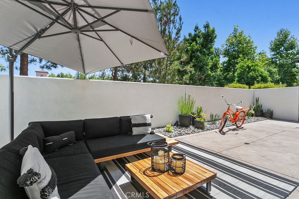 a view of a terrace with furniture and an umbrella