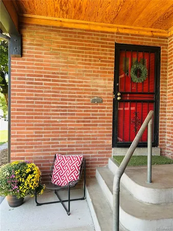 a brick building with a bench and a potted plant