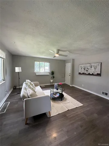 a living room with furniture and a wooden floor