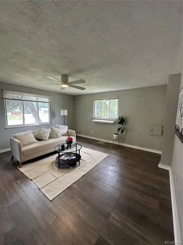 a living room with furniture and a wooden floor