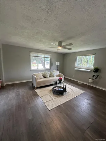 a living room with furniture and a wooden floor