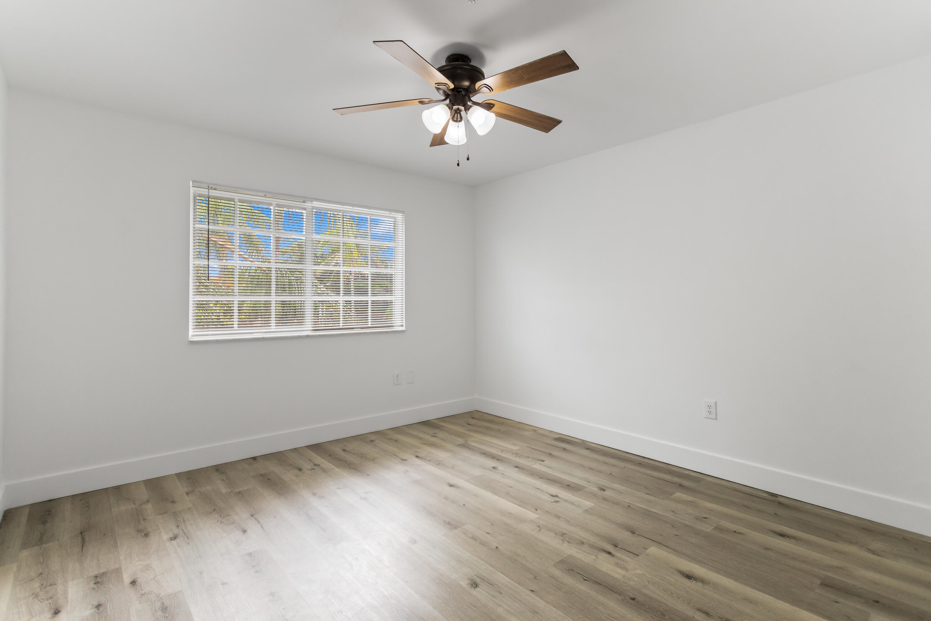 2113 Renaissance Boulevard, Unit 306 Miramar, FL 33025 - Photo 25 of 59 a view of an empty room with wooden floor and a window