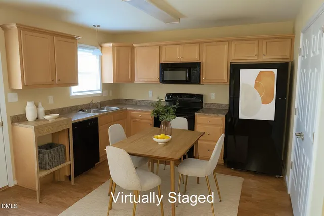 a kitchen with a dining table chairs and microwave