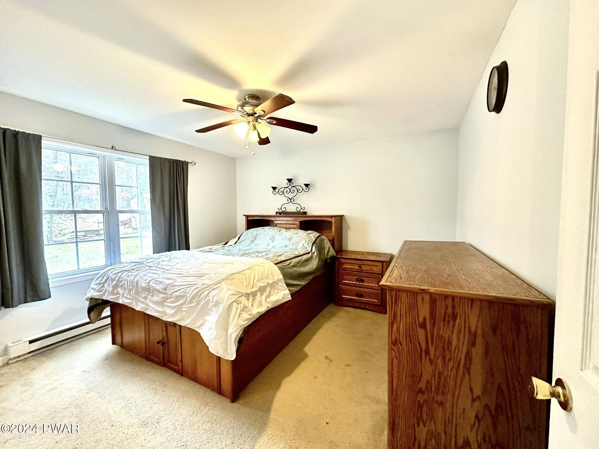 210 Fox Road Dingmans Ferry, PA 18328 - Photo 20 of 38 a bed sitting in a spacious bedroom next to a window