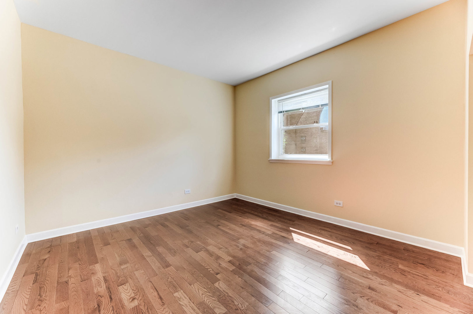 6104 South Dorchester Avenue, Unit 1S Chicago, IL 60637 - Photo 4 of 16 an empty room with wooden floor and windows