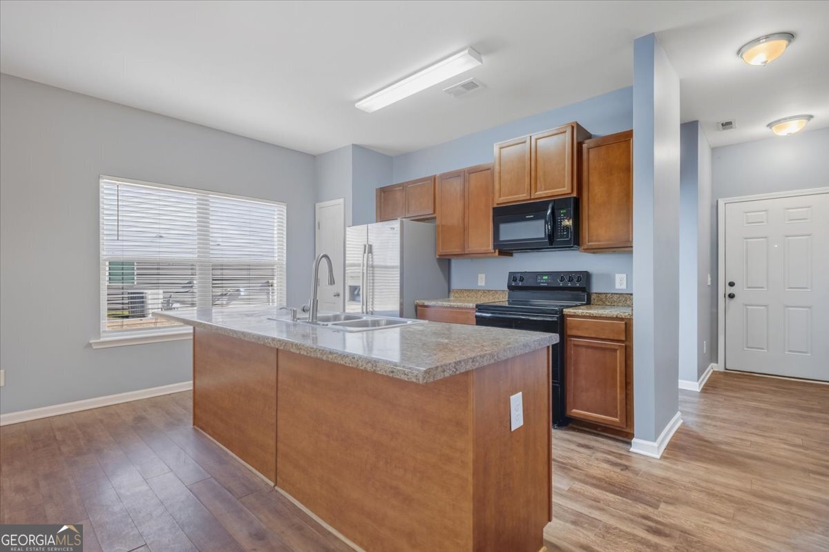 15 Grandberry Court Southwest Rome, GA 30165 - Photo 12 of 23 a kitchen with stainless steel appliances granite countertop a stove a sink a refrigerator and a granite counter tops with wooden floors