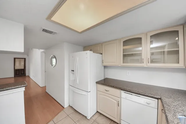 a kitchen with white cabinets and white appliances