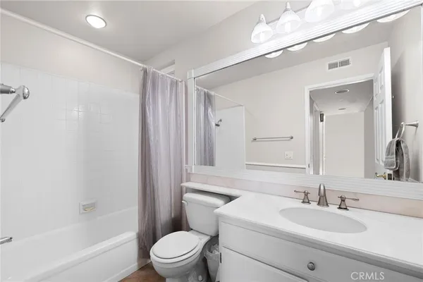 a bathroom with a sink a toilet a mirror and shower