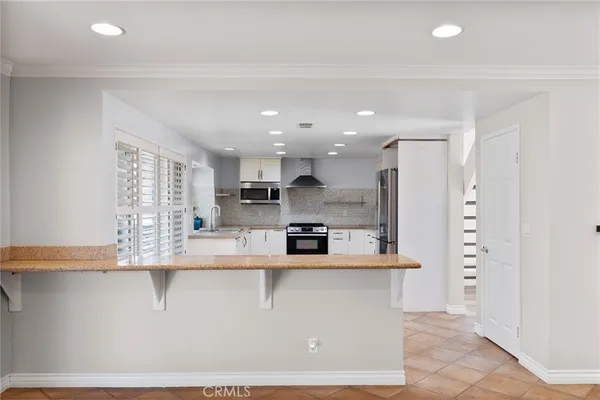 a large kitchen with stainless steel appliances granite countertop a large counter top a stove and a refrigerator