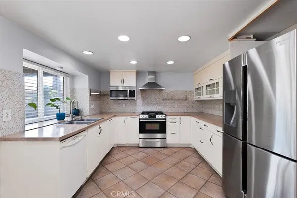 a kitchen with stainless steel appliances granite countertop a refrigerator sink and stove