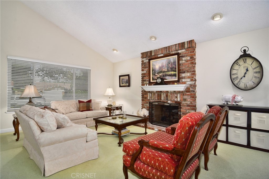23628 Spires Street West Hills, CA 91304 - Photo 9 of 36 a living room with furniture a fireplace and a large window