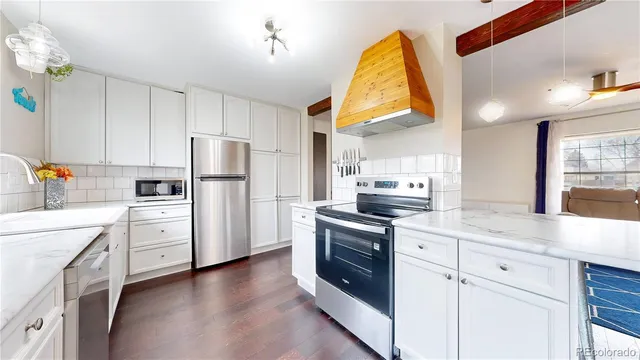 a kitchen with white cabinets and appliances