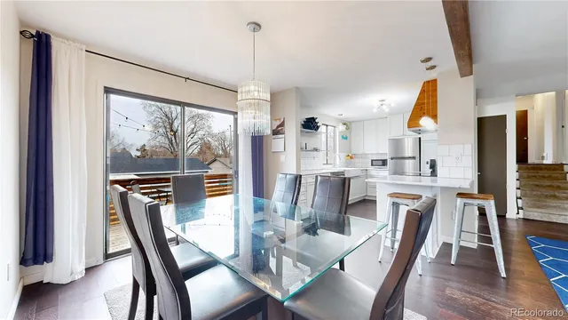 a dining room with furniture a chandelier and wooden floor