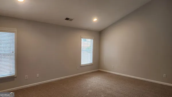 an empty room with windows and closet