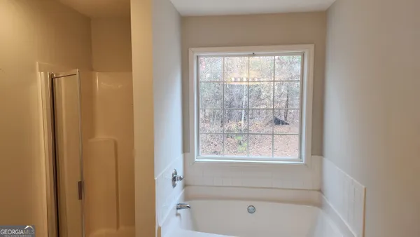 a bathroom with a bathtub next to a window