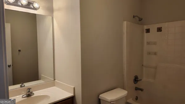 a bathroom with a toilet a sink and mirror