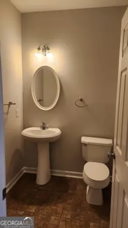 a bathroom with a toilet a sink and a mirror