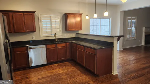 a kitchen with a sink cabinets and wooden floor