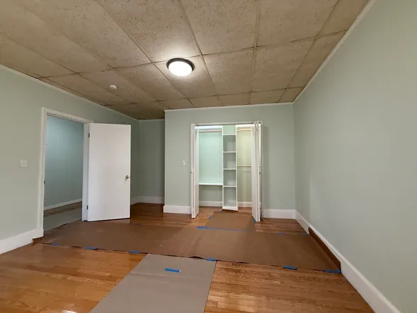 a view of a big room with wooden floor and windows