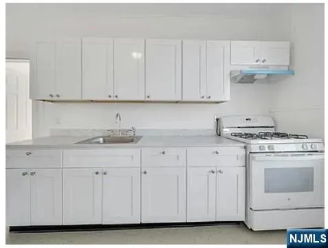 a kitchen with white cabinets and white appliances