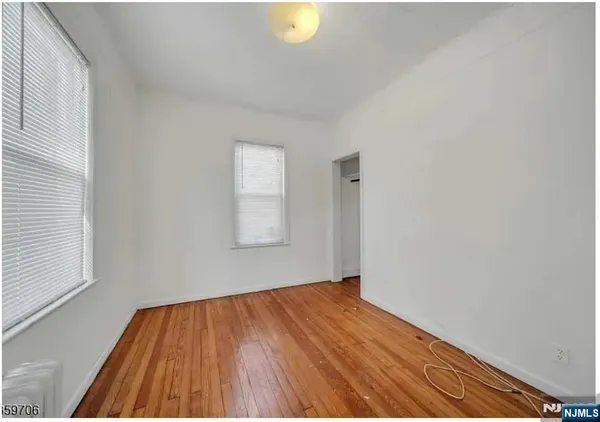 a view of a room with wooden floor and window