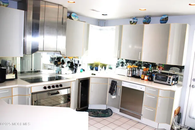 a kitchen with stainless steel appliances granite countertop a sink and a refrigerator