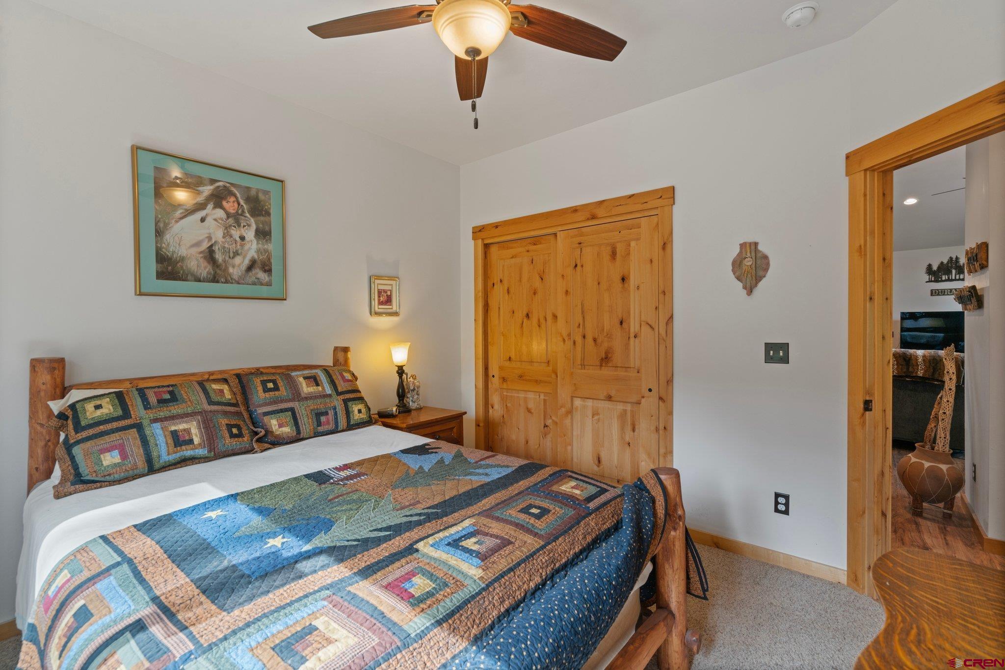105 Window Lake Trail Durango, CO 81301 - Photo 25 of 36 a bedroom with a bed and a chandelier