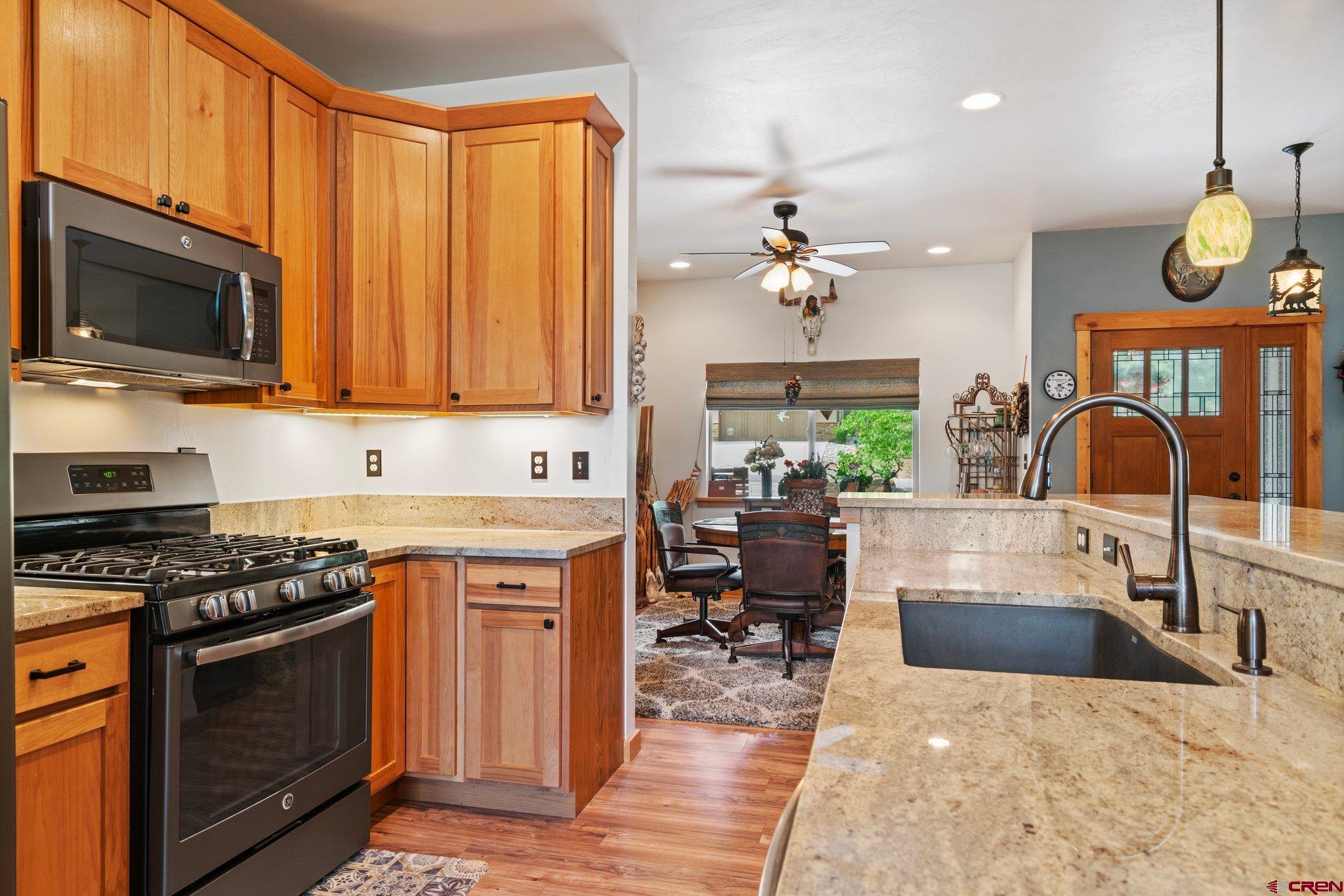 105 Window Lake Trail Durango, CO 81301 - Photo 10 of 36 a kitchen with stainless steel appliances a stove a sink cabinets and a dining table