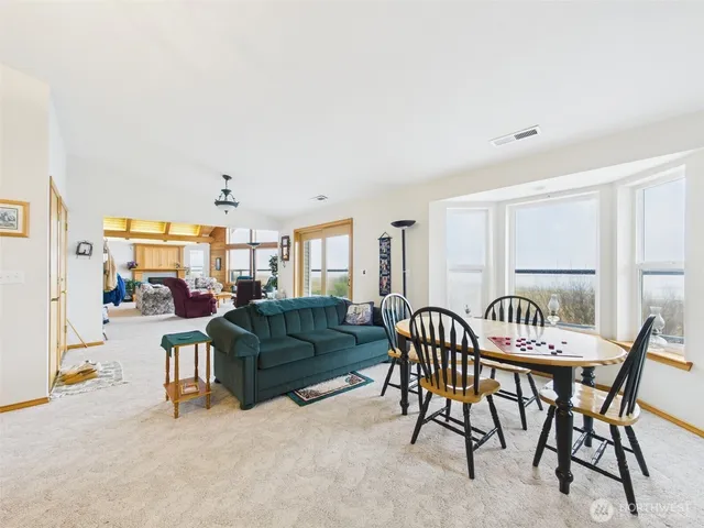 a living room with furniture a flat screen tv and a refrigerator