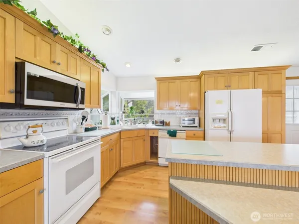 a kitchen with stainless steel appliances a refrigerator sink and microwave