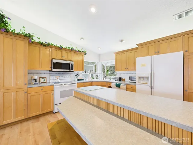 a large kitchen with dining table and chairs