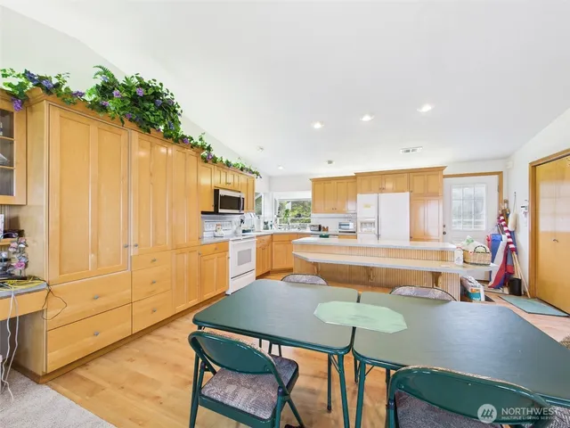 a view of a kitchen with kitchen island a counter top space a sink cabinets and appliances