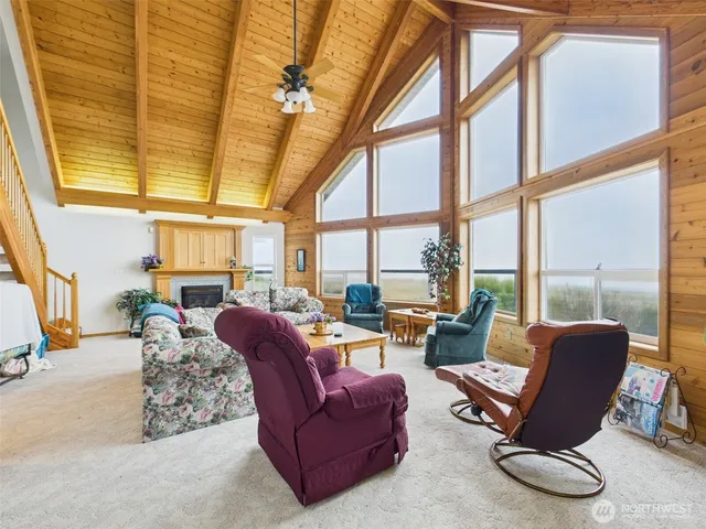 a living room with furniture and floor to ceiling windows