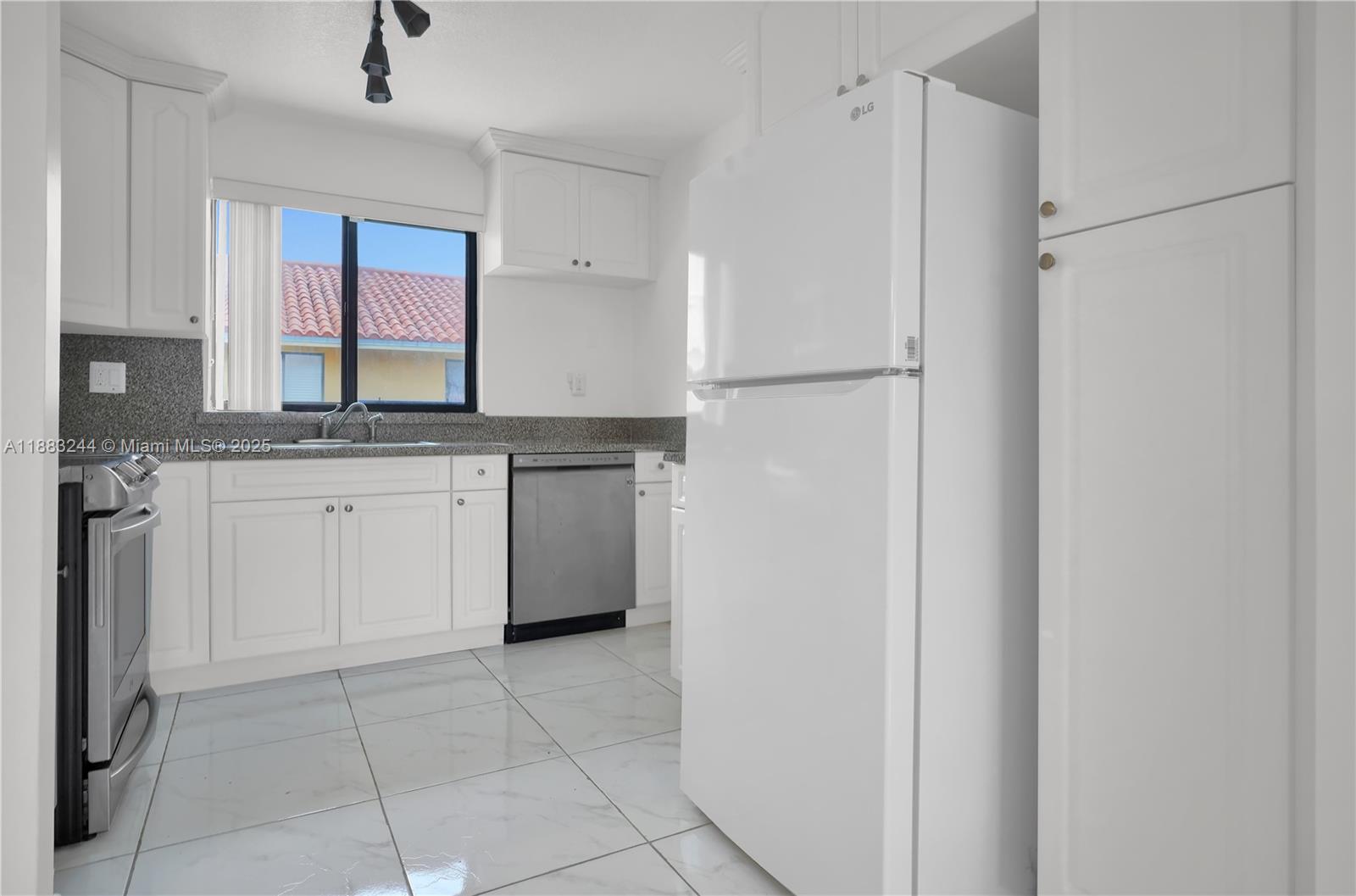 2740 West 61st Street, Unit 204 Hialeah, FL 33016 - Photo 8 of 20 a kitchen with white cabinets and a refrigerator