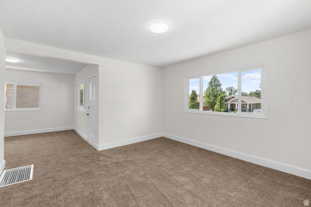 2862 Fowler Avenue Ogden, UT 84403 - Photo 11 of 23 Carpeted interior space featuring an expansive window with a three-pane design, white trim, and a white baseboard