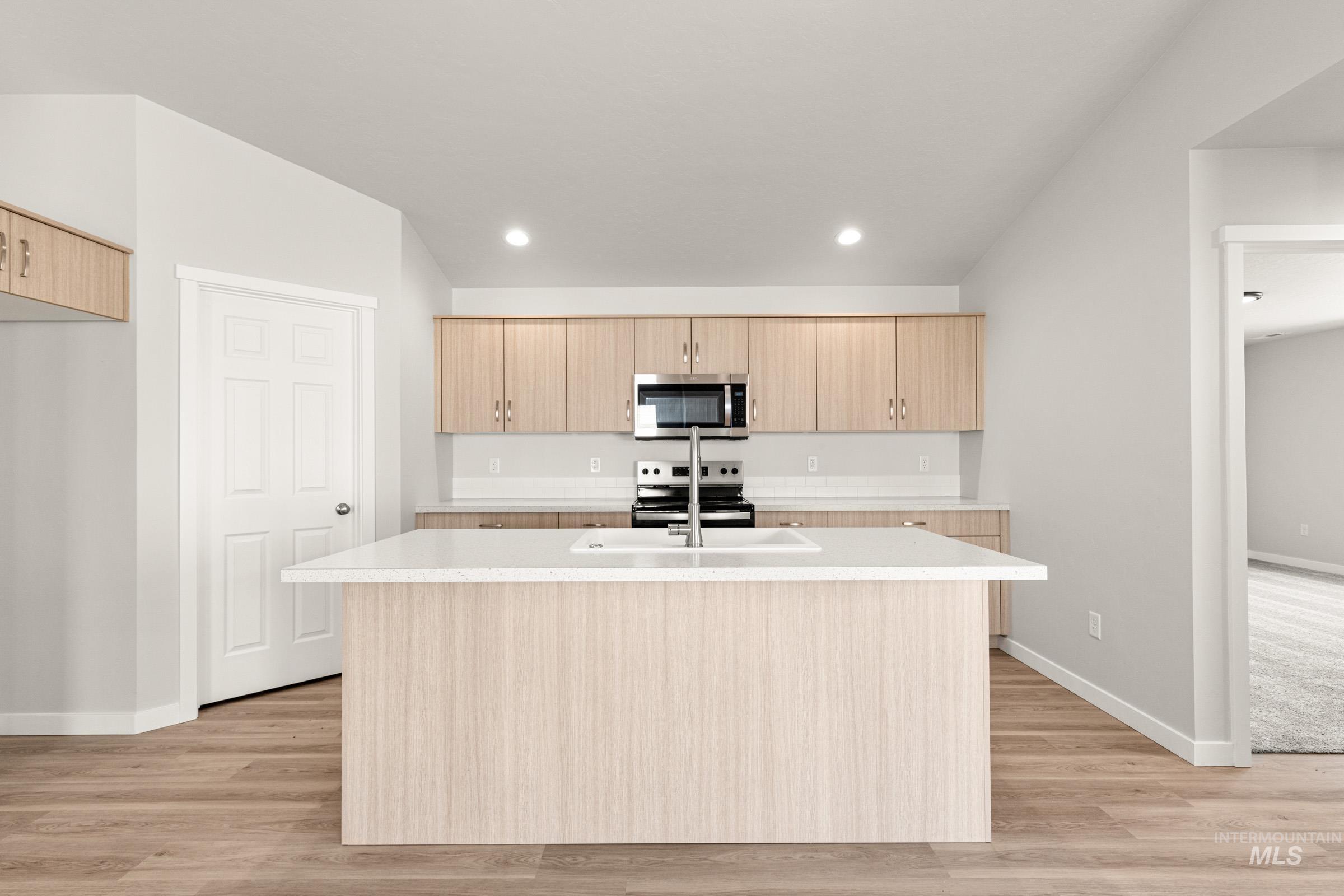 13728 Redway Court Caldwell, ID 83607 - Photo 3 of 19 Kitchen with light wood finish cabinetry, an island with sink, stainless steel appliances, light wood-style flooring, and recessed lighting