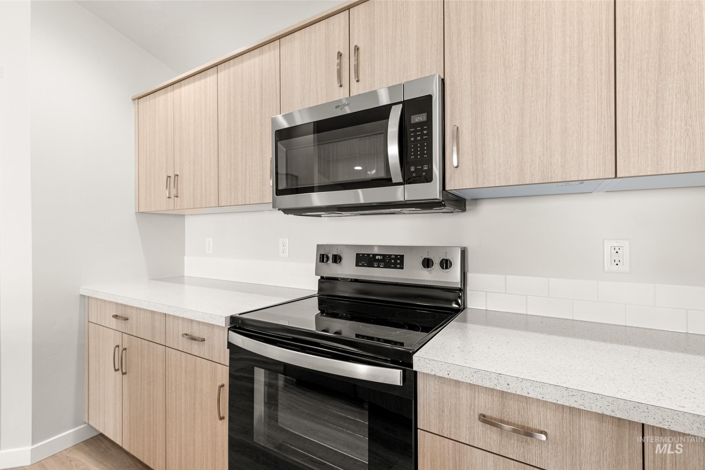 13728 Redway Court Caldwell, ID 83607 - Photo 5 of 19 Kitchen featuring stainless steel appliances, light wood finish cabinetry, and light countertops