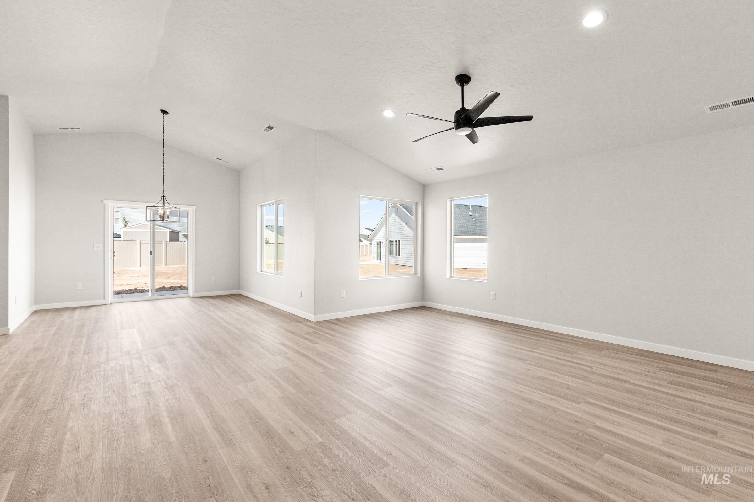 13728 Redway Court Caldwell, ID 83607 - Photo 8 of 19 Unfurnished living room featuring light wood-style flooring, vaulted ceiling, ceiling fan, and hanging lights
