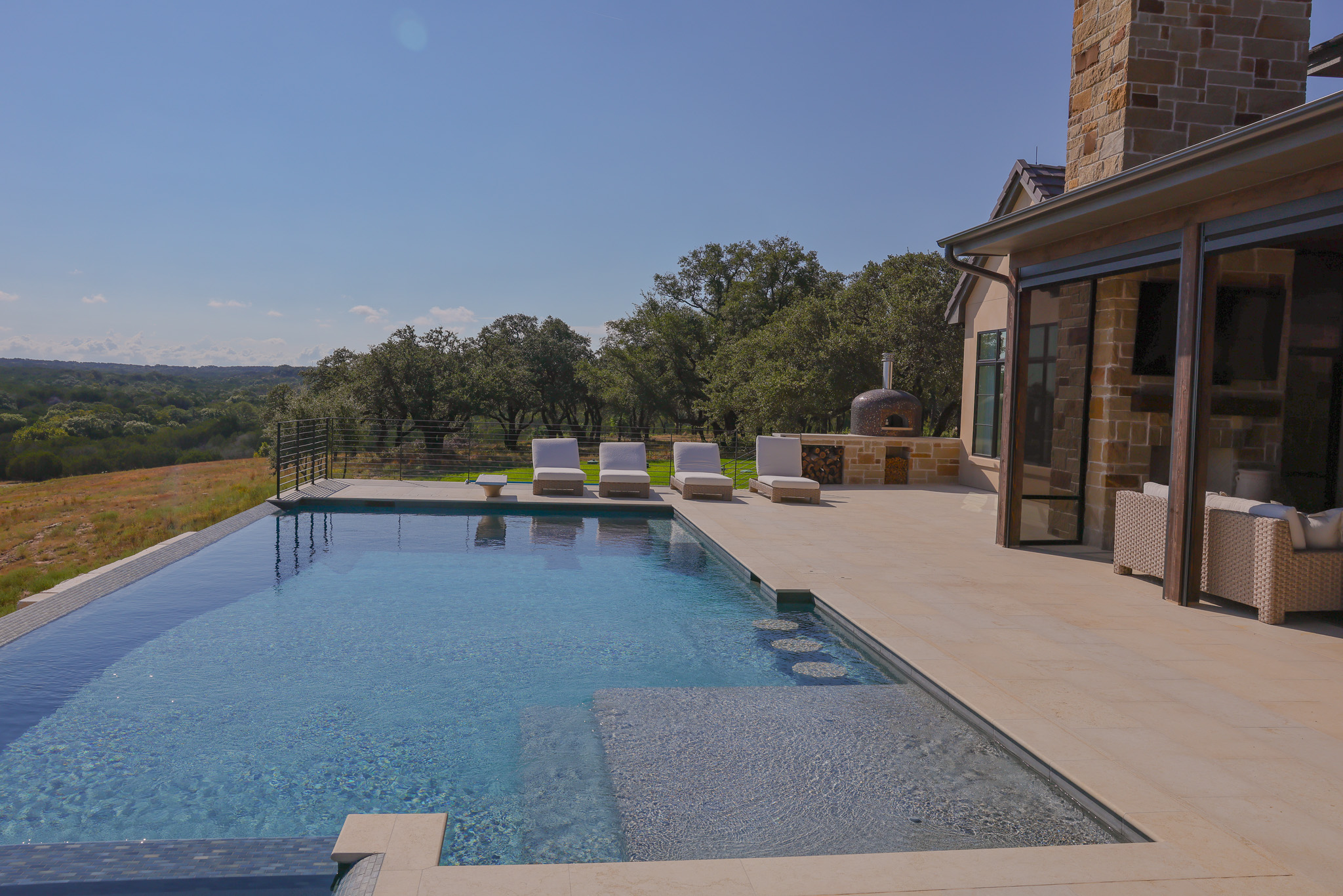 920 Ryan Road Bertram, TX 78605 - Photo 17 of 40 An inviting infinity edge pool overlooks serene rolling hills and lush mature trees.