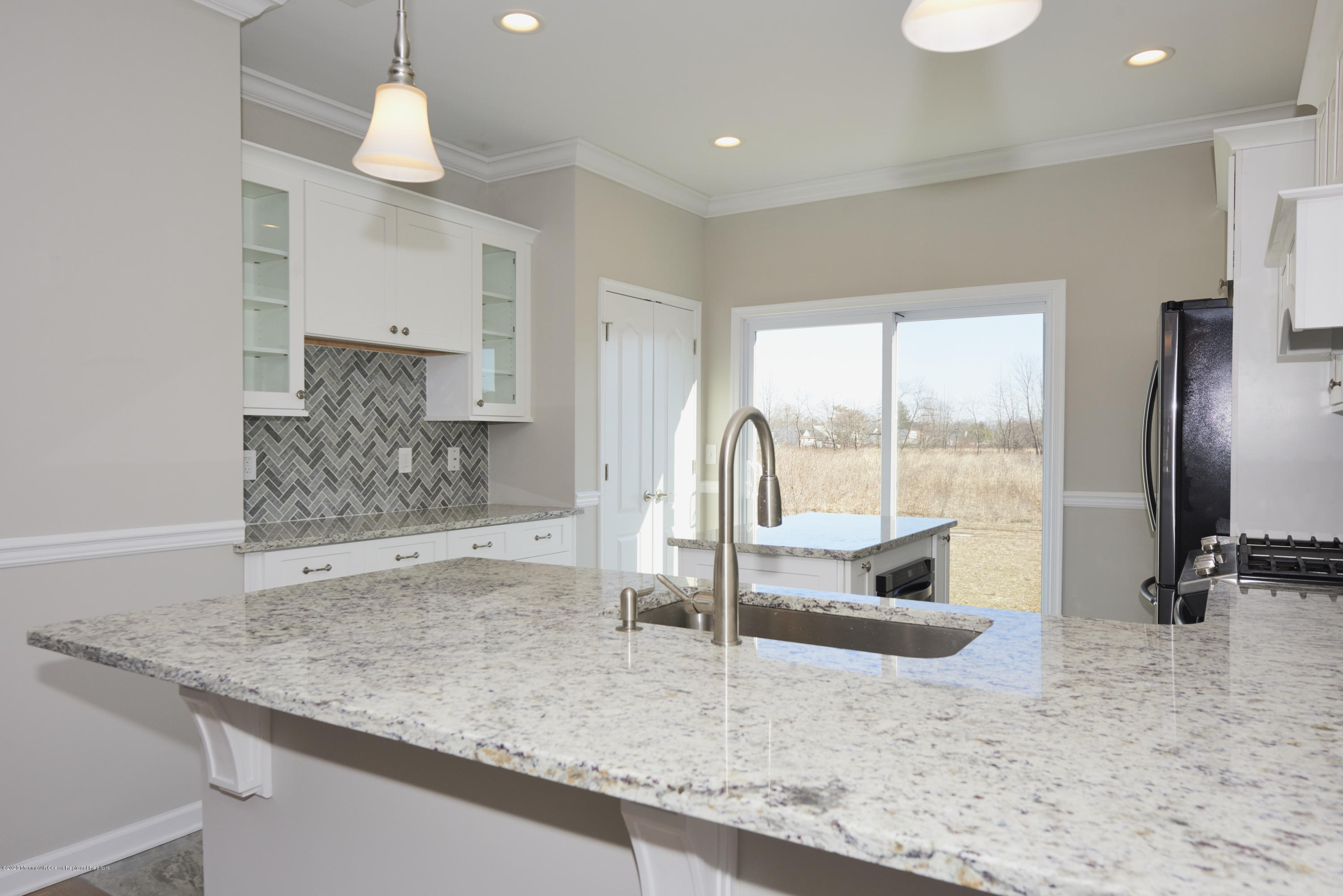 23 Green Tree Circle Hazlet, NJ 07730 - Photo 4 of 38 a kitchen with granite countertop a sink a counter and a refrigerator