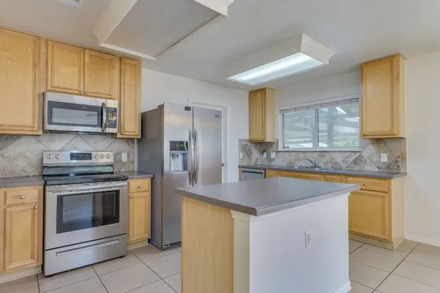 a kitchen with granite countertop white cabinets and stainless steel appliances