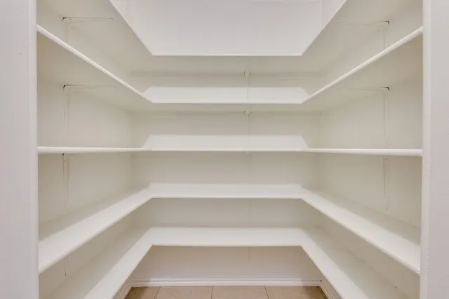 a view of a kitchen with white cabinets appliances and a window