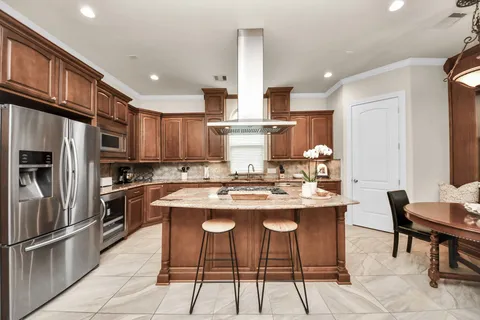 a kitchen with stainless steel appliances kitchen island granite countertop a sink and cabinets
