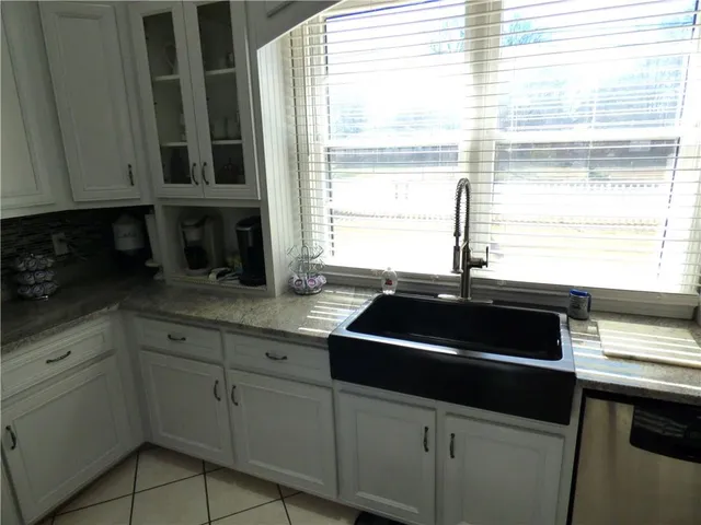 a kitchen with stainless steel appliances a stove a microwave and white cabinets