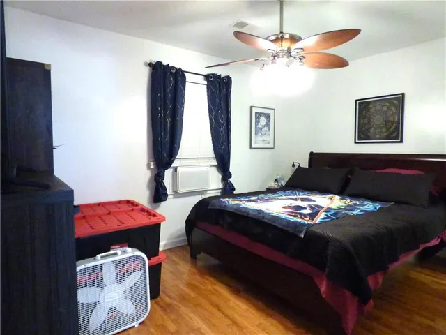 a bedroom with a bed and wooden floor