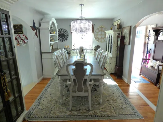 a kitchen with stainless steel appliances granite countertop a sink a stove a refrigerator dining table and chairs