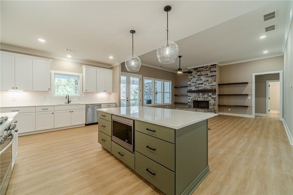 327 Pine Circle Monroe, GA 30655 - Photo 12 of 69 a large kitchen with stainless steel appliances and a wooden floor